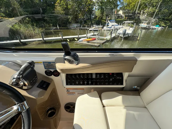 Wining Down Yacht Photos Pics Interior view of 2016 Regal 35 Sport Coupe cockpit with control panel and waterfront scenery.