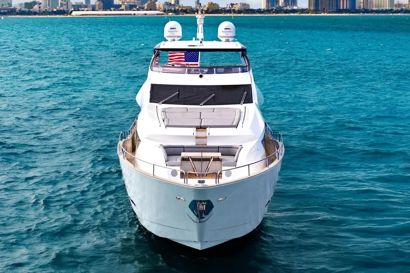 Pura Vida Yacht Photos Pics 2022 Sunseeker Motoryacht on blue ocean, city skyline in background.