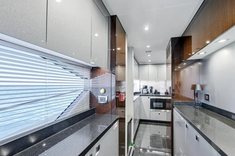 Pura Vida Yacht Photos Pics Luxurious kitchen interior of 2022 Sunseeker Motoryacht with modern appliances and sleek design.