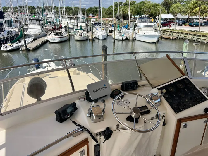 Arvo Arrow Yacht Photos Pics 1985 Chris-Craft 460 Constellation yacht helm with marina view, featuring Garmin navigation.