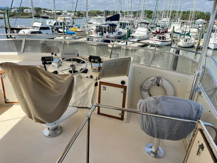 Arvo Arrow Yacht Photos Pics 1985 Chris-Craft 460 Constellation yacht helm with covered seats, overlooking marina.