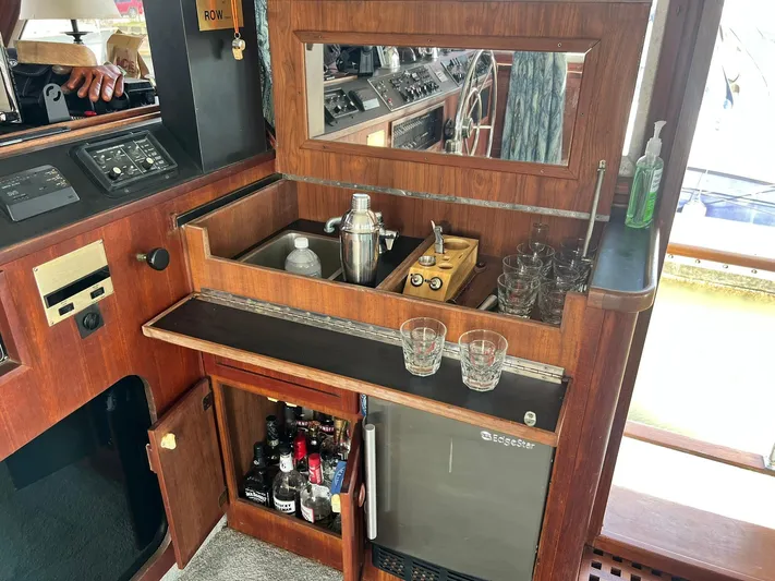Arvo Arrow Yacht Photos Pics 1985 Chris-Craft 460 Constellation yacht interior with bar setup, featuring sink, glasses, and mini fridge.
