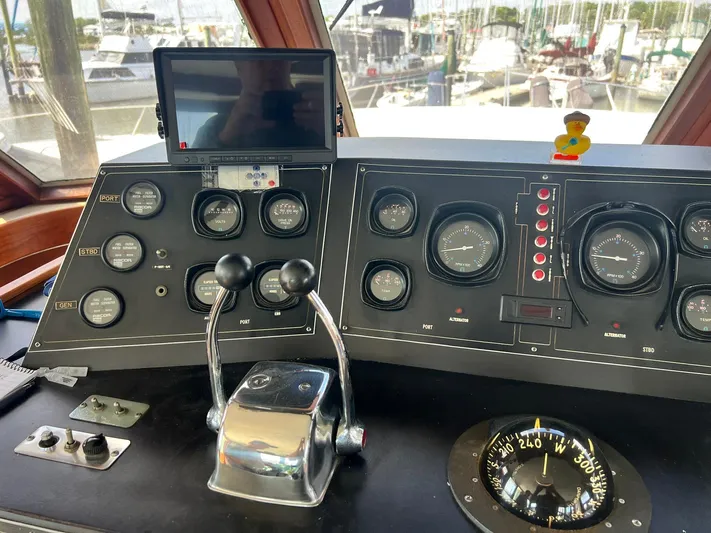 Arvo Arrow Yacht Photos Pics 1985 Chris-Craft 460 Constellation helm with gauges, controls, and compass in a marina setting.