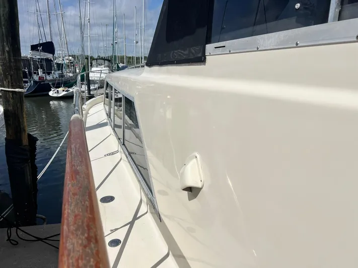 Arvo Arrow Yacht Photos Pics 1985 Chris-Craft 460 Constellation yacht docked, showcasing sleek side view and polished railing.