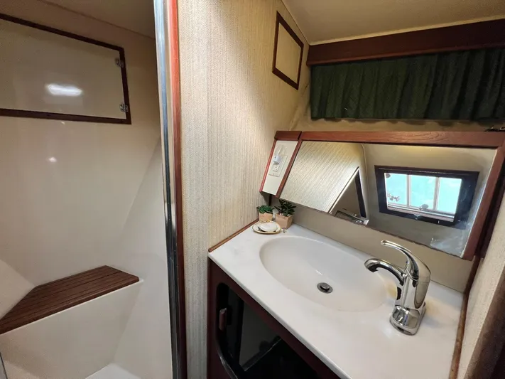 Arvo Arrow Yacht Photos Pics 1985 Chris-Craft 460 Constellation bathroom with sink, mirror, and shower area.