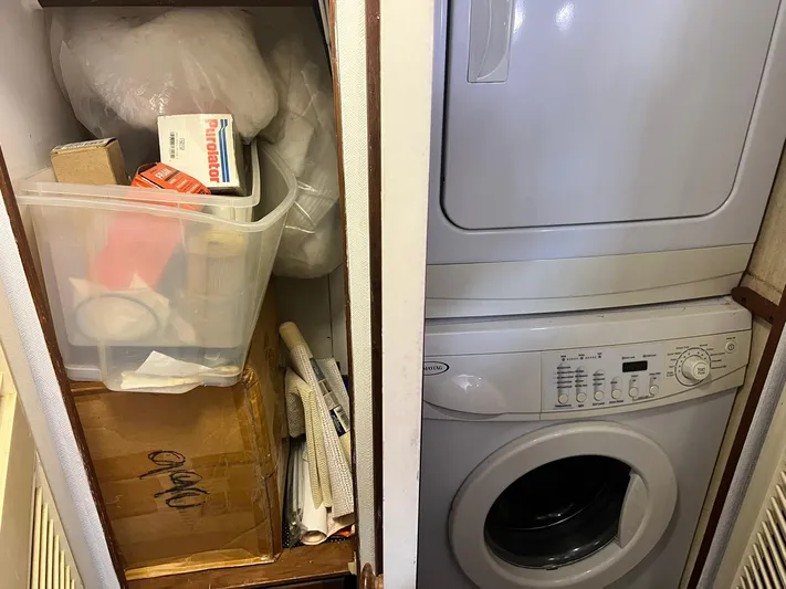 Arvo Arrow Yacht Photos Pics Laundry area with stacked washer-dryer and storage on a 1985 Chris-Craft 460 Constellation.