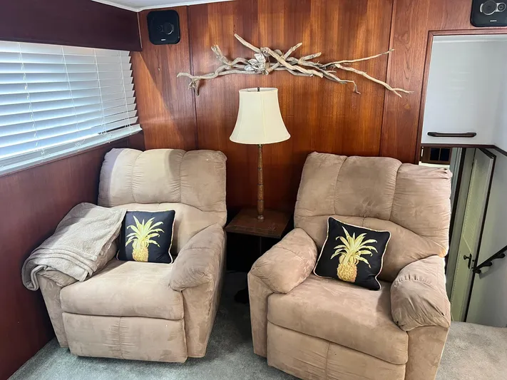 Arvo Arrow Yacht Photos Pics Two beige recliners with pineapple pillows in a cozy room on a 1985 Chris-Craft 460 Constellation.