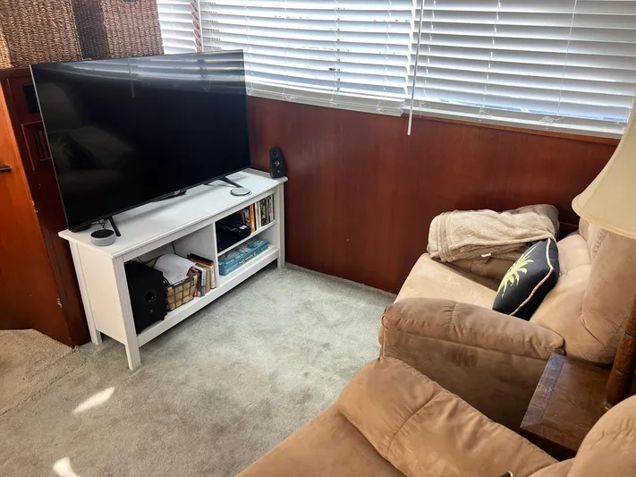 Arvo Arrow Yacht Photos Pics Cozy living area on 1985 Chris-Craft 460 Constellation with TV, recliner, and bookshelf.