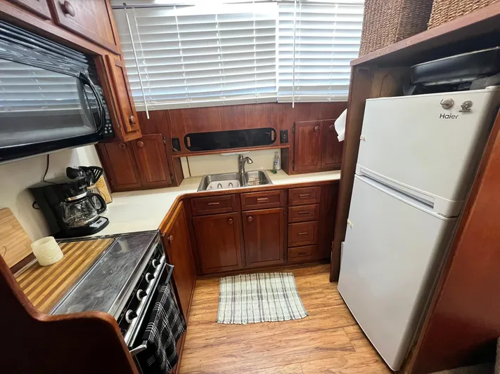 Arvo Arrow Yacht Photos Pics 1985 Chris-Craft 460 Constellation kitchen with wood cabinetry, stove, and refrigerator.