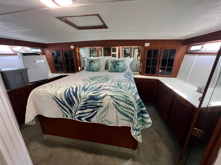 Arvo Arrow Yacht Photos Pics 1985 Chris-Craft 460 Constellation bedroom with tropical bedding and wooden cabinetry.