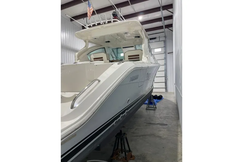  Yacht Photos Pics 2024 Pursuit DC 326 Dual Console boat in storage, showcasing sleek design and modern features.