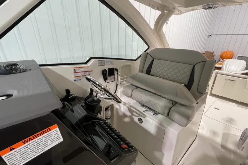  Yacht Photos Pics 2024 Pursuit DC 326 Dual Console interior with steering wheel and cushioned seating.