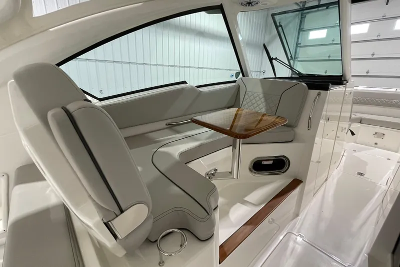  Yacht Photos Pics 2024 Pursuit DC 326 Dual Console interior with elegant seating and wooden table.