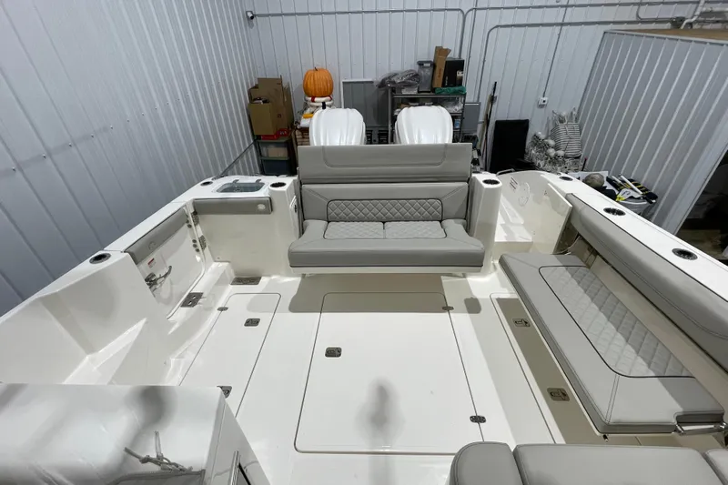  Yacht Photos Pics 2024 Pursuit DC 326 Dual Console boat interior with gray seating and storage compartments.