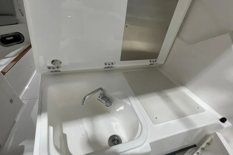  Yacht Photos Pics 2024 Pursuit DC 326 Dual Console boat sink and faucet in white interior.
