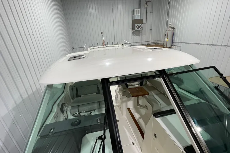  Yacht Photos Pics 2024 Pursuit DC 326 Dual Console boat in indoor storage, showcasing sleek design and spacious interior.