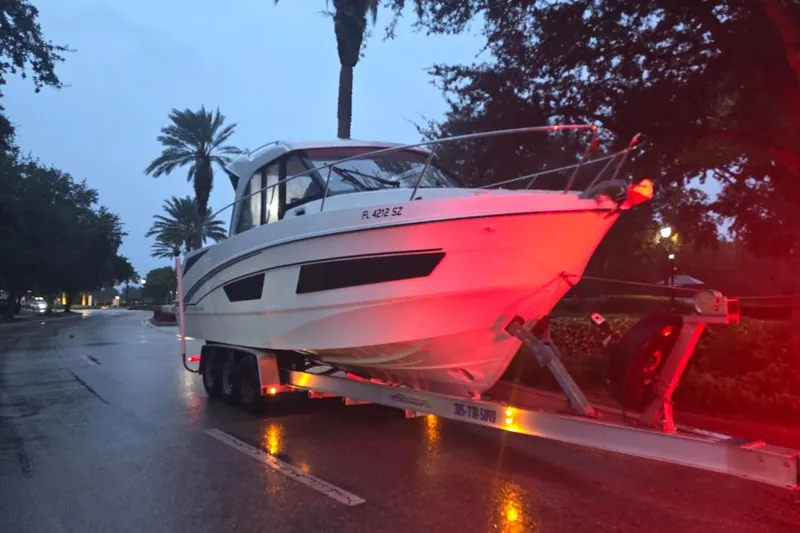  Yacht Photos Pics 2021 Beneteau Antares 9 on trailer, evening street scene with palm trees.