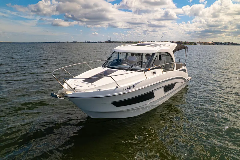  Yacht Photos Pics 2021 Beneteau Antares 9 boat cruising on open water under a partly cloudy sky.