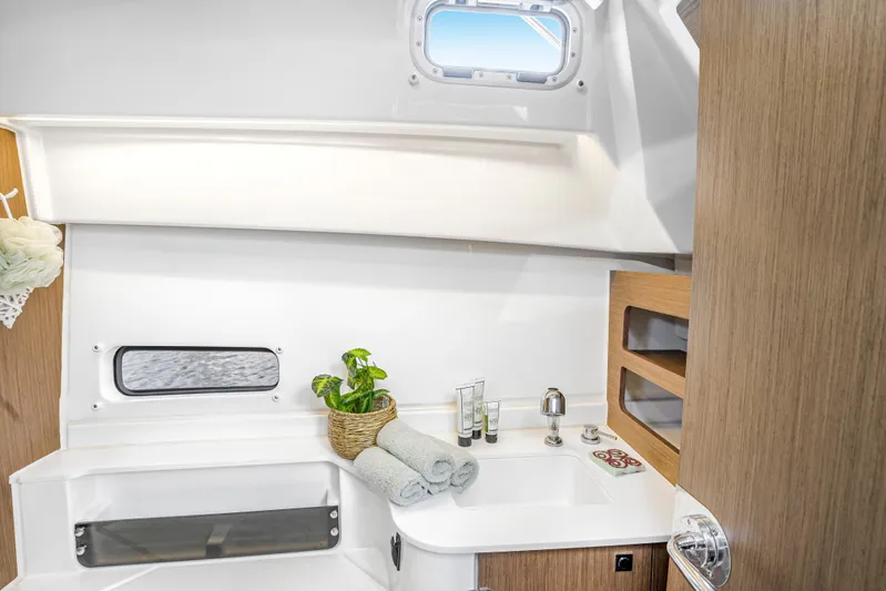  Yacht Photos Pics Modern bathroom interior of 2021 Beneteau Antares 9 boat with sink and porthole.