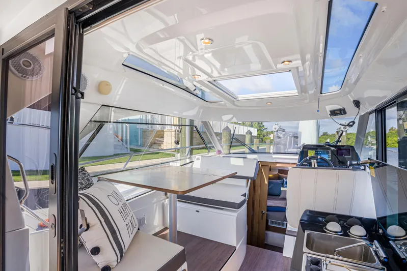  Yacht Photos Pics Interior of 2021 Beneteau Antares 9 boat with modern seating and skylights.