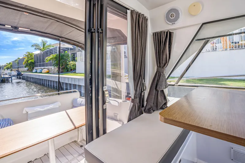  Yacht Photos Pics Interior view of 2021 Beneteau Antares 9 boat, featuring seating and waterfront scenery.