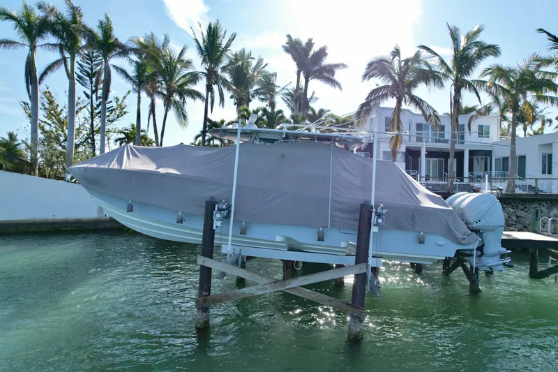  Yacht Photos Pics 2020 SeaVee 370z boat covered and elevated near waterfront home with palm trees.