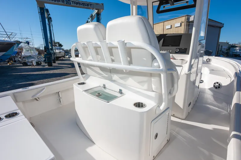 Our Trade Yacht Photos Pics 2024 Regulator 26XO boat interior with seating and control panel in a marina setting.