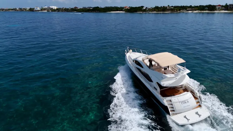 Itaca Yacht Photos Pics Luxurious 2008 Sunseeker Manhattan 60 yacht cruising on clear blue waters.