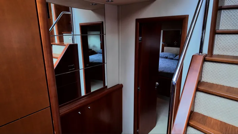 Itaca Yacht Photos Pics Interior of 2008 Sunseeker Manhattan 60 yacht, featuring wooden stairs and mirrored walls.