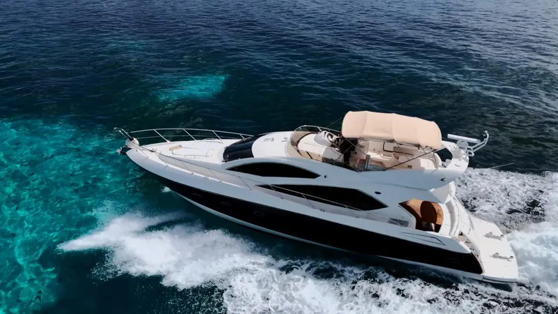 Itaca Yacht Photos Pics Luxurious 2008 Sunseeker Manhattan 60 yacht cruising on clear blue ocean waters.