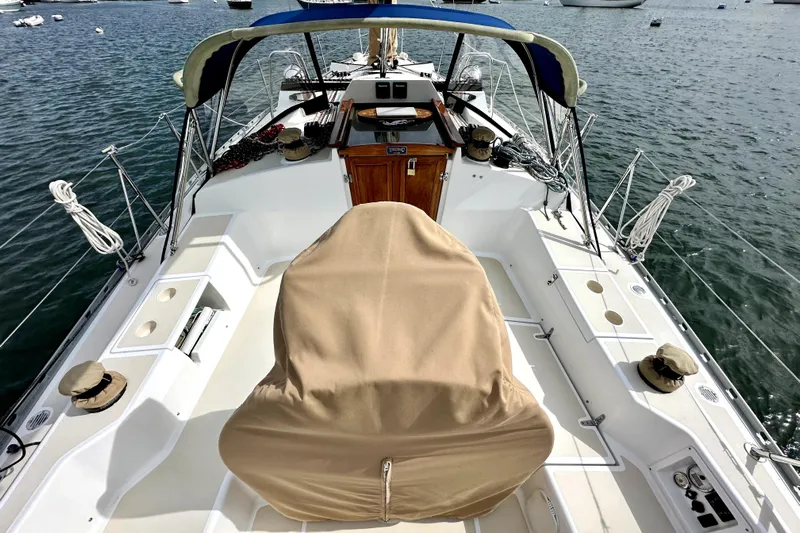 Blue Aweigh Yacht Photos Pics 2021 Tartan 345 sailboat deck with covered helm, moored on calm water.