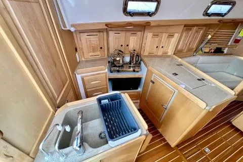 Blue Aweigh Yacht Photos Pics Modern Tartan 345 yacht kitchen with wooden cabinetry and sleek countertops, 2021 model.