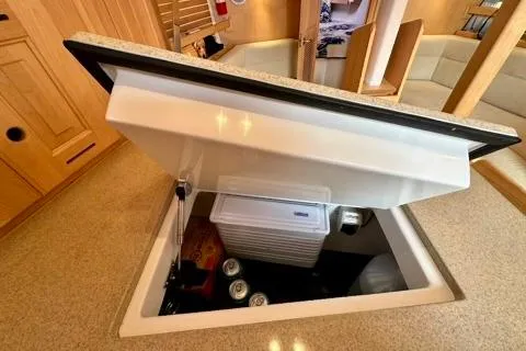 Blue Aweigh Yacht Photos Pics Hidden storage compartment in 2021 Tartan 345 yacht interior, featuring beverages and cooler.