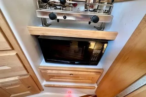 Blue Aweigh Yacht Photos Pics Compact kitchen area in a 2021 Tartan 345 with microwave and stove.