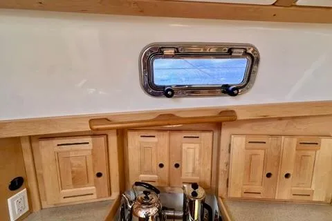 Blue Aweigh Yacht Photos Pics Interior of 2021 Tartan 345 sailboat with wooden cabinets and a small window.