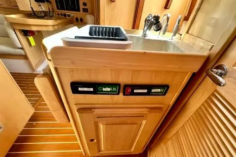 Blue Aweigh Yacht Photos Pics 2021 Tartan 345 yacht interior with wooden cabinetry and compact kitchen sink.