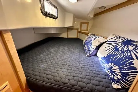 Blue Aweigh Yacht Photos Pics Cozy cabin interior of 2021 Tartan 345 yacht with comfortable bedding and decorative pillows.
