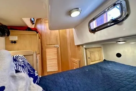 Blue Aweigh Yacht Photos Pics Interior of 2021 Tartan 345 sailboat cabin with cozy bedding and wooden accents.