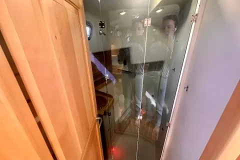 Blue Aweigh Yacht Photos Pics Interior of 2021 Tartan 345 yacht with wooden cabinetry and glass door.