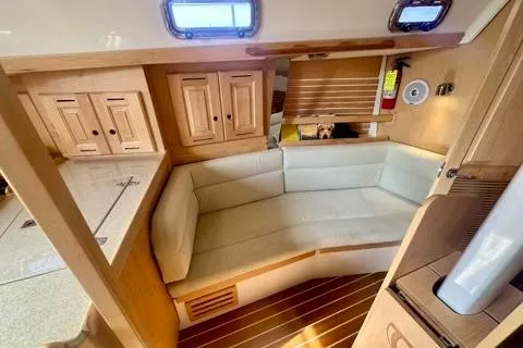 Blue Aweigh Yacht Photos Pics 2021 Tartan 345 yacht interior with cozy seating and wooden cabinetry.