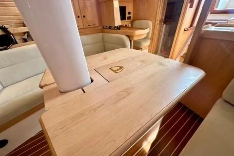 Blue Aweigh Yacht Photos Pics Interior of 2021 Tartan 345 yacht with wooden table and seating area.