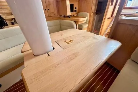 Blue Aweigh Yacht Photos Pics Interior of 2021 Tartan 345 yacht with wooden table and seating area.