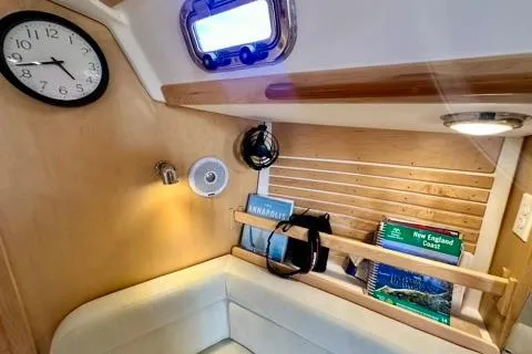 Blue Aweigh Yacht Photos Pics Interior of 2021 Tartan 345 sailboat with clock, books, and cozy seating area.