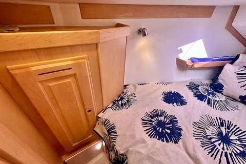 Blue Aweigh Yacht Photos Pics Cozy cabin interior of 2021 Tartan 345 yacht with floral bedding and wooden cabinetry.