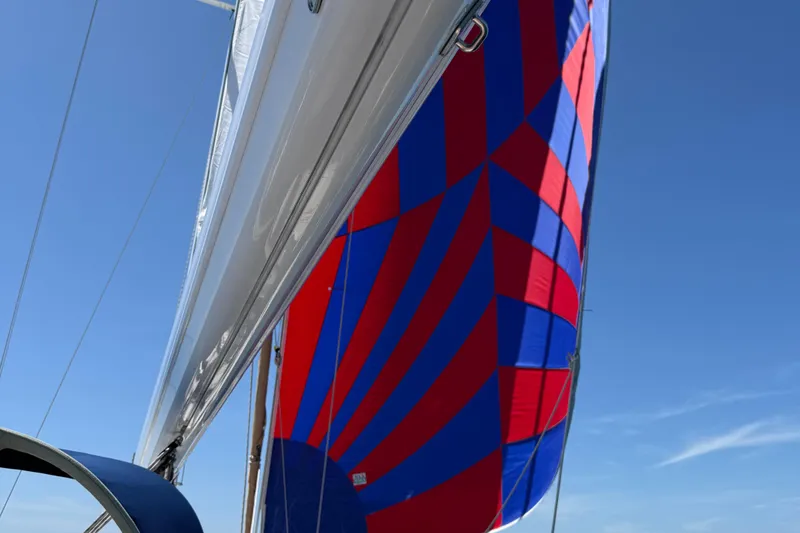 Blue Aweigh Yacht Photos Pics Sailboat with vibrant red and blue spinnaker, Tartan 345 model, 2021.