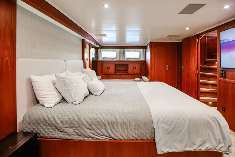 Kapal Yacht Photos Pics Luxurious bedroom interior on a 1971 Feadship yacht, featuring elegant wood paneling and modern decor.