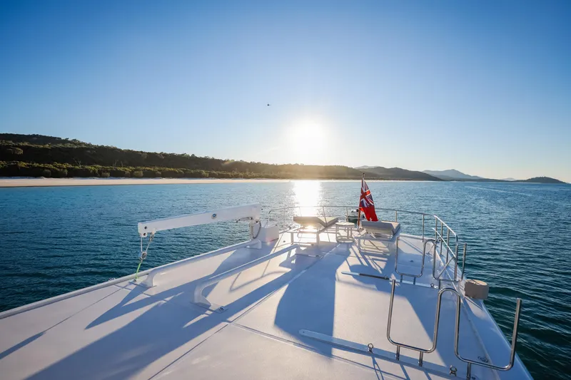 Kapal Yacht Photos Pics Feadship yacht deck overlooking serene ocean and coastline at sunrise, 1971 model.