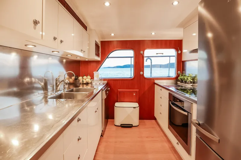 Kapal Yacht Photos Pics Luxurious yacht kitchen interior with stainless steel counters, wooden accents, and ocean view windows. Feadship 1971.
