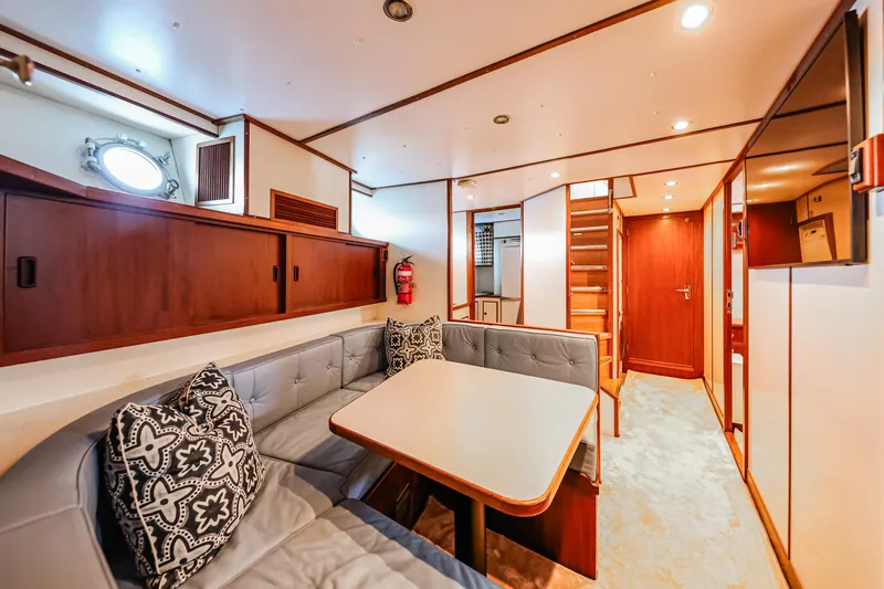 Kapal Yacht Photos Pics Interior of a 1971 Feadship yacht with cozy seating and wooden accents.