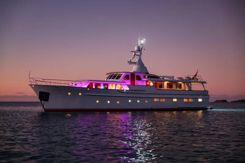 Kapal Yacht Photos Pics Luxurious 1971 Feadship yacht illuminated at sunset on calm waters.